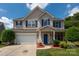 Charming two-story home featuring blue shutters, a well-manicured lawn, and a two-car garage at 461 Pier Point Nw Ct, Concord, NC 28027