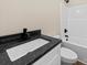 Bathroom with a black granite countertop, white vanity and combination shower at 503 Eddleman Rd, Kannapolis, NC 28083