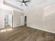 Spacious bedroom with tray ceiling, ceiling fan, wood-look flooring, and access to the bath at 503 Eddleman Rd, Kannapolis, NC 28083