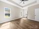 Light-filled bedroom featuring a tray ceiling, ceiling fan, and wood-look flooring at 503 Eddleman Rd, Kannapolis, NC 28083