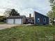 Exterior shot of home with two-car garage and well-maintained lawn, showcasing its setting and charm at 5050 Forest Ridge Dr, Hickory, NC 28602