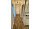 A hallway with wood look floors leads to a white front door with sidelight, and a glimpse of a kitchen at 5050 Forest Ridge Dr, Hickory, NC 28602