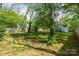 Lush backyard with mature trees and a well-kept lawn, providing a tranquil outdoor space at 56 Blume Sw Ave, Concord, NC 28025