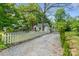 Exterior view showcasing a gravel driveway and a home with a white picket fence at 56 Blume Sw Ave, Concord, NC 28025