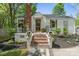 Charming home featuring a brick chimney, black and white awning, brick steps, and mature landscaping at 56 Blume Sw Ave, Concord, NC 28025