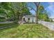 Beautifully landscaped front yard with a charming house, mature trees, and a classic picket fence at 56 Blume Sw Ave, Concord, NC 28025