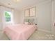 Bright bedroom features a pink bed, floral wallpaper and white trim at 5916 Rexwood Pl, Charlotte, NC 28210