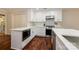 Bright kitchen features white cabinets, hardwood floors, stainless appliances, and an island with modern countertops at 5916 Rexwood Pl, Charlotte, NC 28210