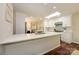 Bright kitchen features white cabinets, hardwood floors, stainless appliances, island with seating and modern finishes at 5916 Rexwood Pl, Charlotte, NC 28210