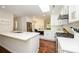 Bright kitchen with stainless appliances, hardwood floors, white cabinets, island with seating, and a modern skylight at 5916 Rexwood Pl, Charlotte, NC 28210