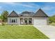 Charming one-story home boasts a manicured lawn, inviting front porch, attached two-car garage, and neutral siding at 604 Airport Rd, Kannapolis, NC 28081