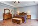 Comfortable primary bedroom with a tray ceiling, wooden flooring, a ceiling fan, and an en-suite bathroom at 604 Airport Rd, Kannapolis, NC 28081