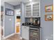Stylish bar area with granite countertop, mini fridge, and glass cabinets, perfect for entertaining guests at 657 Portside Dr, Davidson, NC 28036