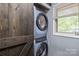 Stackable washer and dryer in laundry area, concealed by sliding barn door, adds convenience to the home at 657 Portside Dr, Davidson, NC 28036