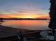 Stunning sunset view from the porch overlooking the peaceful lake and sandy beach at 657 Portside Dr, Davidson, NC 28036
