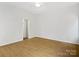 A bright bedroom featuring natural hardwood floors, white walls, and a modern ceiling fan at 6647 Vlosi Dr, Charlotte, NC 28226