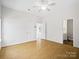 Spacious, light-filled bedroom with wood floors, ceiling fan, and an adjacent bathroom at 6647 Vlosi Dr, Charlotte, NC 28226
