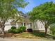 Charming two-story home featuring a well-manicured lawn, lush greenery, and a classic white exterior at 6647 Vlosi Dr, Charlotte, NC 28226