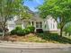Well-maintained home with green lawn, mature trees, and tidy landscaping around the foundation at 6647 Vlosi Dr, Charlotte, NC 28226