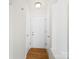 Hallway featuring hardwood floors, neutral walls, and multiple doors for easy access at 6647 Vlosi Dr, Charlotte, NC 28226