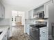 Charming kitchen with stainless steel appliances, gray cabinets, and a view into the living area at 6647 Vlosi Dr, Charlotte, NC 28226