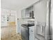 Bright kitchen with stainless steel appliances, grey cabinets, and an adjacent view of the living area at 6647 Vlosi Dr, Charlotte, NC 28226