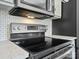 A close-up view of a modern electric cooktop with light grey cabinets and quartz countertops at 6647 Vlosi Dr, Charlotte, NC 28226