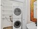 A laundry area featuring a stacked washer and dryer next to a white vanity sink at 6647 Vlosi Dr, Charlotte, NC 28226