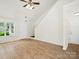 Well-lit living room with wood floors, ceiling fan, staircase, and view to the front yard at 6647 Vlosi Dr, Charlotte, NC 28226