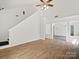 Bright living room with wood floors, a ceiling fan, and an open floor plan at 6647 Vlosi Dr, Charlotte, NC 28226