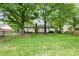 Expansive backyard with lush lawn, mature trees, and a charming patio area perfect for entertaining at 6718 Summerlin Pl, Charlotte, NC 28226