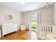 Light-filled Bedroom with hardwood floors, crib, and large window at 6718 Summerlin Pl, Charlotte, NC 28226