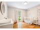 Bright Bedroom with hardwood floors, a white crib, and large windows at 6718 Summerlin Pl, Charlotte, NC 28226