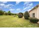View of the backyard with grass, trimmed hedges, and a fire pit at 6849 Blake Brook Dr, Concord, NC 28025