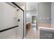 Bathroom features a shower, tile flooring, wood cabinets, gray walls, and a door leading to another room at 6849 Blake Brook Dr, Concord, NC 28025
