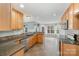 Well-lit kitchen with wooden cabinets, granite countertops, stainless steel appliances, and tile flooring at 6849 Blake Brook Dr, Concord, NC 28025