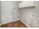 The laundry room has tile floors, utility connections, cabinets, and a door to the outside at 6849 Blake Brook Dr, Concord, NC 28025