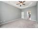 Empty main bedroom with neutral colors, carpet, ceiling fan, and en-suite bathroom ready for decorating at 6849 Blake Brook Dr, Concord, NC 28025