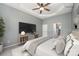 Staged main bedroom with ceiling fan, neutral colors, carpet, en-suite bathroom, TV and entertainment center at 6849 Blake Brook Dr, Concord, NC 28025