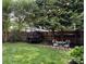 Landscaped backyard featuring lush lawn, mature trees, and decorative string lights for outdoor enjoyment at 7409 Gilderstern Glen Ct, Huntersville, NC 28078