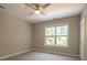 Bright bedroom featuring a ceiling fan and a large window with natural light at 7409 Gilderstern Glen Ct, Huntersville, NC 28078