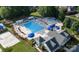 An aerial shot shows the community pool with blue umbrellas, a sand volleyball court, and lush landscaping at 7409 Gilderstern Glen Ct, Huntersville, NC 28078