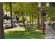 A picturesque park featuring lush greenery, park benches, and decorative lighting, with retail visible in the background at 7409 Gilderstern Glen Ct, Huntersville, NC 28078