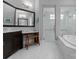 Modern bathroom featuring double sink vanity, soaking tub, and glass-enclosed shower at 767 Pinnacle Dr, Iron Station, NC 28080