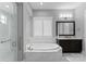 Modern bathroom featuring large soaking tub, glass-enclosed shower, and double sink vanity at 767 Pinnacle Dr, Iron Station, NC 28080