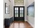 Elegant entryway with glass paneled double doors, hardwood floors, and stylish decor at 767 Pinnacle Dr, Iron Station, NC 28080