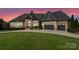 Beautiful stone and brick home with an attached three-car garage and a well-manicured lawn at 767 Pinnacle Dr, Iron Station, NC 28080