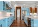Modern kitchen featuring stainless steel appliances, blue cabinets, and a large island with a farmhouse sink at 767 Pinnacle Dr, Iron Station, NC 28080