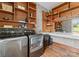 Well-organized laundry room with wooden shelves, a large mirror, and modern appliances at 767 Pinnacle Dr, Iron Station, NC 28080
