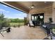 Spacious covered patio with a brick accent wall, comfortable seating, and scenic views of the backyard at 767 Pinnacle Dr, Iron Station, NC 28080